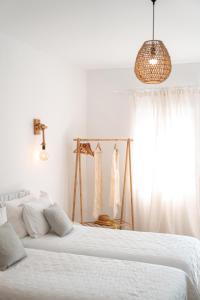 格拉斯托斯La Stella Stay的一间白色卧室,配有两张床和窗户