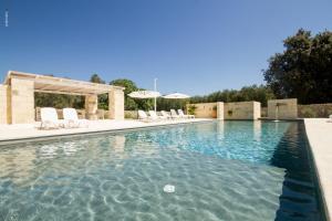 圣安德烈亚Agriturismo La Turrita的一个带白色椅子的游泳池和一个游泳池