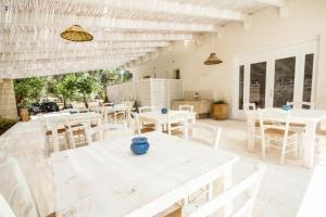 圣安德烈亚Agriturismo La Turrita的庭院配有白色的桌子和白色的椅子。