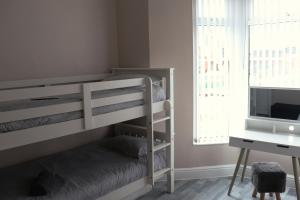 利物浦Kop View的一间卧室配有双层床和书桌