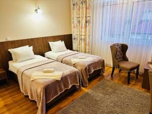 图兹拉HOTEL MINERO的酒店客房,配有两张床和椅子