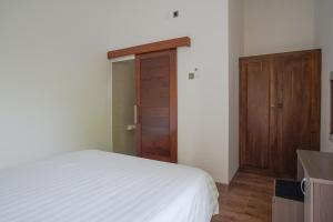 沙努尔Rumah Kecil Sanur的卧室配有白色的床和木门