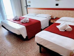 里米尼Ben Hur Rimini的两张位于酒店客房的床,配有毛巾