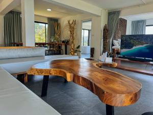 Baan Khai塔诺伊花园度假屋的客厅配有木制咖啡桌