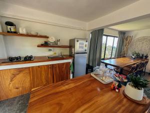 Baan Khai塔诺伊花园度假屋的厨房配有木桌和冰箱。