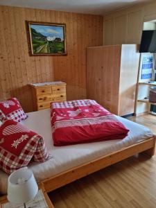 达沃斯Pension Hof zur Stilli的一间卧室配有一张带红色枕头的床