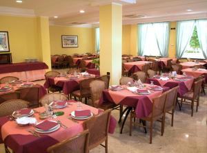 里米尼Ben Hur Rimini的用餐室配有桌椅和粉红色的桌布
