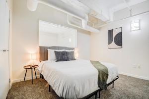 印第安纳波利斯CozySuites - 2BR with Direct Skybridge Access #9的一间白色客房内配有一张大床的卧室