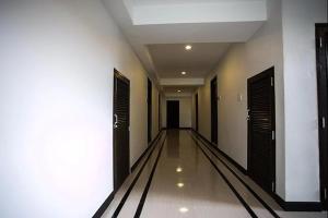 乌隆他尼The Season Airport Udonthani的一条空的走廊,有黑色的门和白色的墙壁