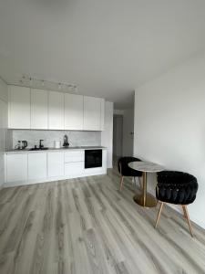 布拉迪斯拉发Ein Park Apartment with free parking的厨房配有白色橱柜和桌椅