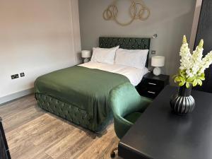 PinnerLetzi Private En-Suite In Harrow的一间卧室配有一张床和一把绿色椅子