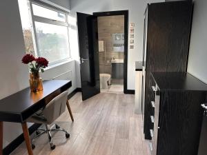 PinnerLetzi Private En-Suite In Harrow的客房设有书桌和带卫生间的浴室。