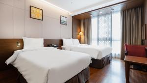 全州市Gloucester Hotel Jeonju的酒店客房设有两张床和窗户。