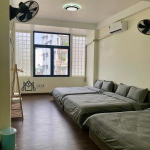 áº¤p VÄ©nh ÃÃ´ngDeMi Homestay 2 - Châu Đốc的一间卧室设有两张床和窗户。