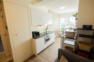 埃因霍温Stylish 50m² Two-Bedroom Apartment (SD-23-K)的客厅设有带柜台和桌子的厨房
