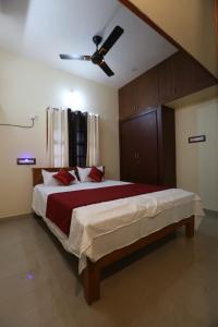 库姆巴科纳姆ABOORVA GRAND INN _ HOMESTAY_ ROOMS _RESORT _HOTEL IN KUMBAKONAM的一间卧室配有一张大床和吊扇