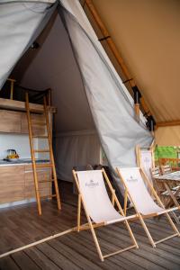 班斯卡 - 什佳夫尼察ForRest Glamping的帐篷内的2把椅子和1张床