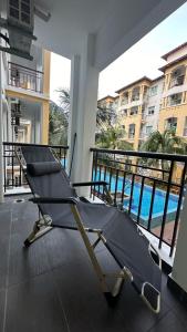 Bandar PenawarDesaru Homestay Southern, Tiara Desaru Seaview Residensi的游泳池景阳台的椅子