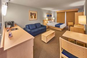 普埃布拉城市快捷普埃布拉芬萨酒店的客厅配有蓝色的沙发和床。