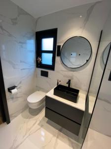 埃尔默洛Luxe 4- persoons Veluwelodge met hottub in Ermelo!的一间带水槽和卫生间的浴室