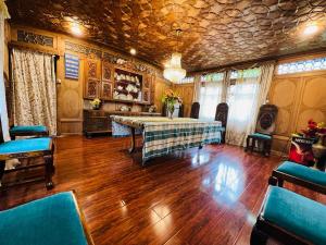 斯利那加The Hayat Group Of Houseboats的大房间设有桌子和蓝色椅子