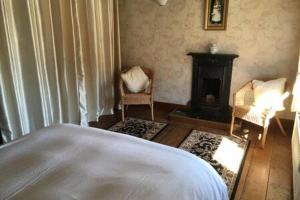 斯泰兹LetAway - Captain Cook's Cottage, Staithes的客厅设有一张床和一个壁炉