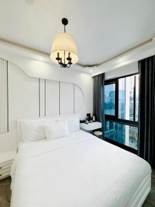 顺化SALA HOTEL HUE的卧室设有白色的床和大窗户