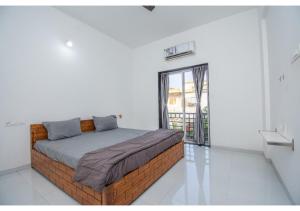 罗纳瓦拉Netflixx Villa的一间卧室设有一张床和一个大窗户