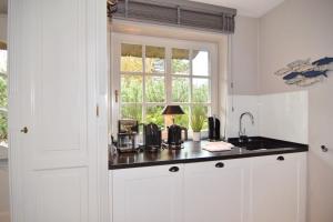 提努姆Gartenweg 9, Whg Oland的厨房设有水槽和窗户。