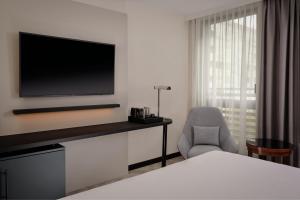阿尔克伊万豪巴黎阿克伊度假酒店的酒店客房带电视和椅子