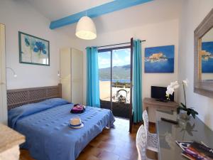 普罗普里亚诺Résidence Maquis Bella Vista的一间卧室配有一张带桌子和一张书桌的床。