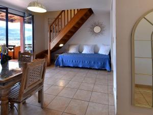 普罗普里亚诺Résidence Maquis Bella Vista的一间卧室配有一张带蓝色床单的床和楼梯。
