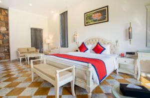 Thāna GhāziSpree Resort Sariska的卧室配有带红色枕头的大型白色床