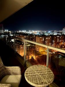 布拉迪斯拉发Sunny Apartment with amazing Terrace on the 13th floor near City Center的夜间阳台上的桌椅