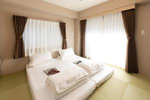 东京灯光旅館 Light hotel的窗户客房内的一张大白色床