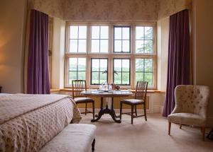 Bronllys朗格伊德大厅酒店的一间卧室配有桌椅和窗户。