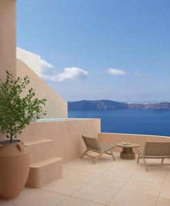 伊亚Annouso Villa with Hot Tub by Caldera Houses的一个带椅子和盆栽植物的庭院和大海