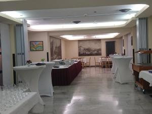 卢加诺切雷西奥酒店的用餐室配有白色的桌子和白色的椅子