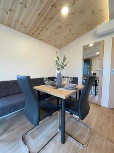 纳堡Tinyhaushotel - Campingpark Nabburg的一间带木桌和椅子的用餐室