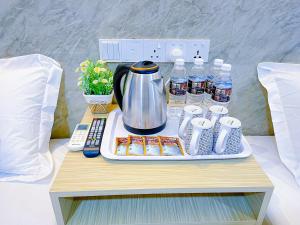 吉隆坡StarQ Hotel Bukit Bintang的茶壶和桌子上的瓶装水托盘