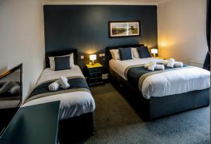 卡莱尔坎布里亚公园酒店的酒店客房,设有两张带蓝色墙壁的床