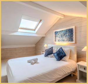 MarcellazVilla T5 Luxury Marcellaz的卧室配有白色床和天窗