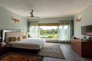 法里达巴德BluSalzz Collection - Siddha Wellness Village, Faridabad - Haryana的一间卧室设有一张大床和一个大窗户