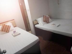 香港Crystal Hostel的小客房内的两张床,配有白色床单
