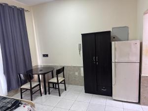 阿吉曼Studio for rent的厨房配有冰箱和桌椅