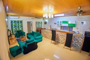 迪亚尼海滩Diani Home Stays的一间带绿色家具的客厅和厨房