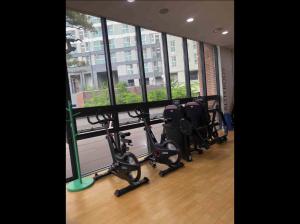首尔Hoban Apartment, KonKuk Univ Station的窗户前设有一排椅子的健身房