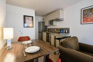 里尔Lille Centre - Superb bright apartment parking的厨房以及带木桌和椅子的用餐室。