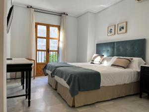 科尔多瓦梅斯特雷酒店的一间卧室配有一张大床和一张书桌