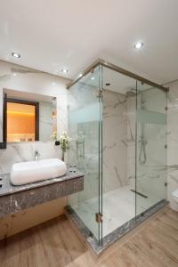 马拉喀什SWISS CONTINENTAL HOTEL Free Cooking Classes的一间带玻璃淋浴和水槽的浴室
